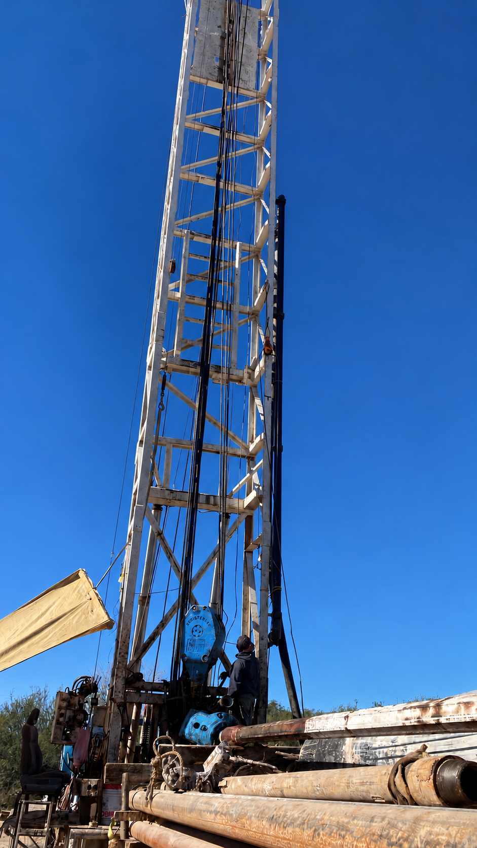 Columna de bomba siendo izada con grúa en campo