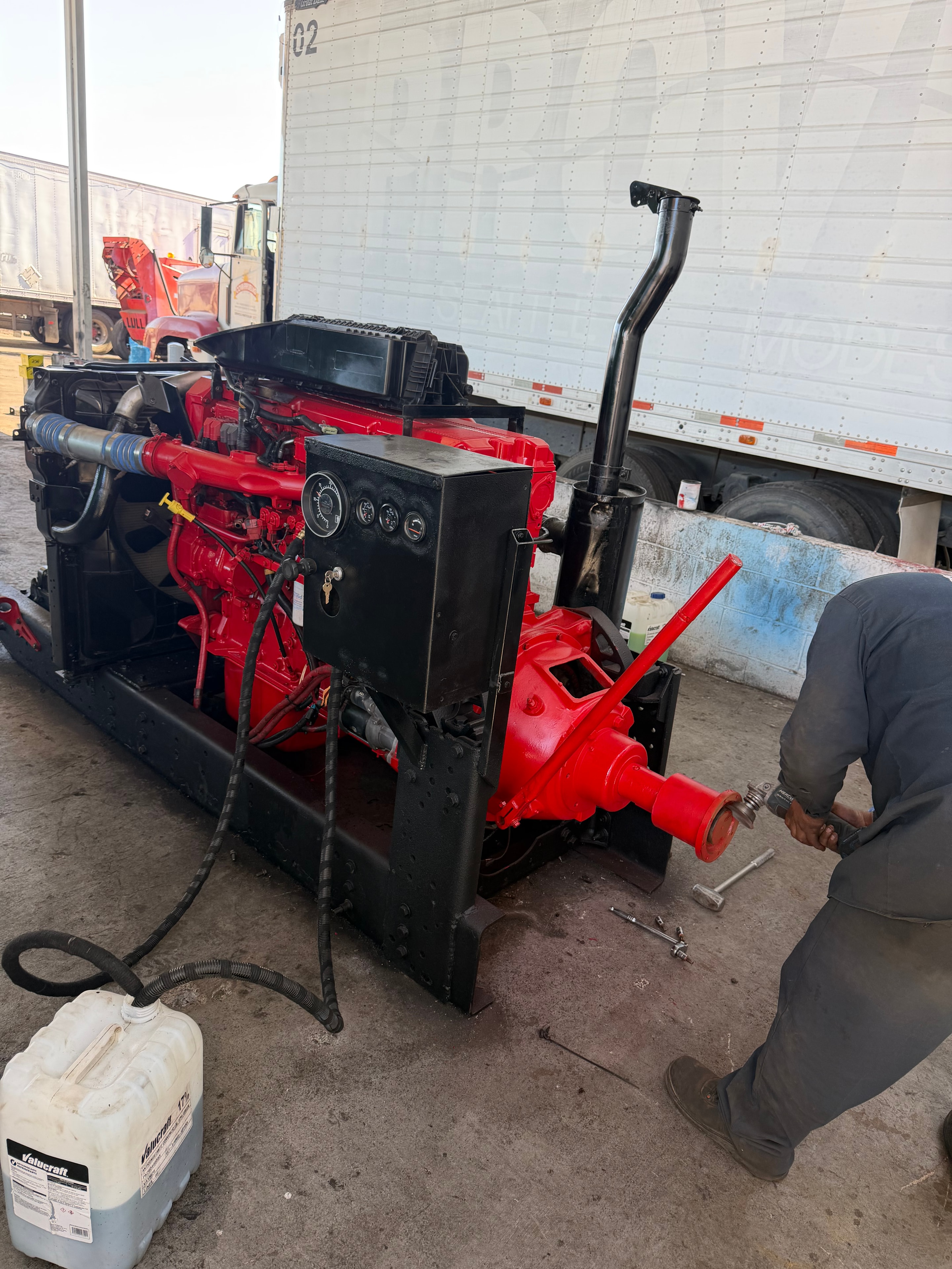 Técnico reparando motor rojo en taller 2MJ
